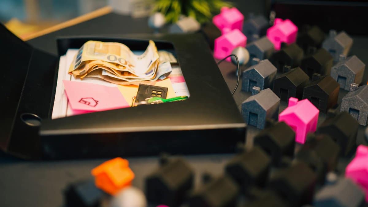 Real estate investment concept with money and house models on table.