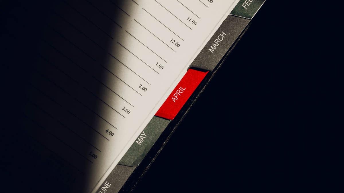 A close-up shot of a planner highlighting the month of April with visible monthly tabs.