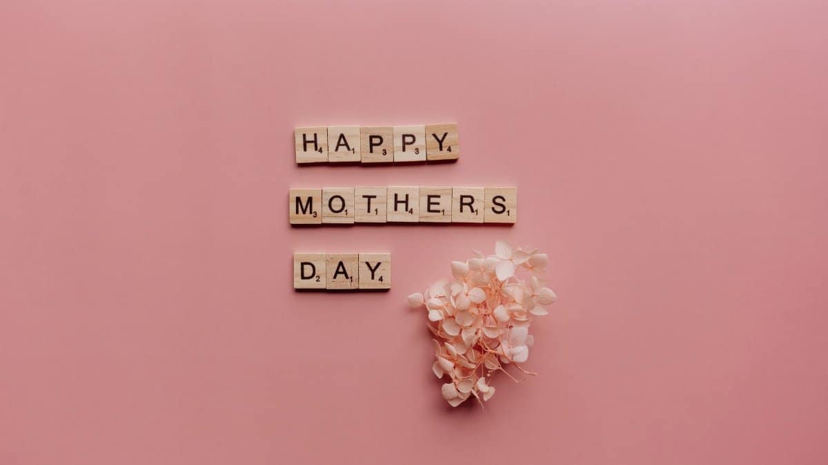 Celebrate Mother's Day with a heartfelt message and pink flowers on a serene pink background.