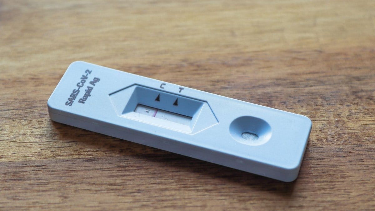 Close-up of a COVID-19 rapid antigen test on a wooden surface for health screening.