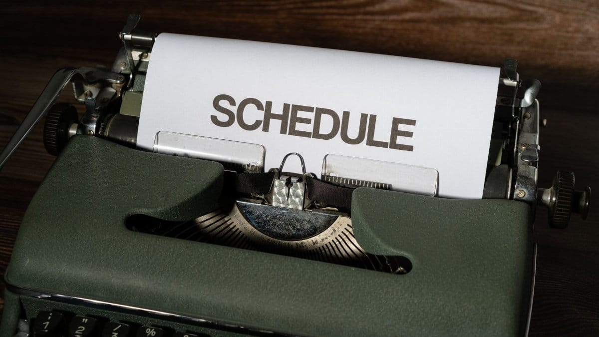 A vintage typewriter with the word 'SCHEDULE' typed on white paper, conveying planning.