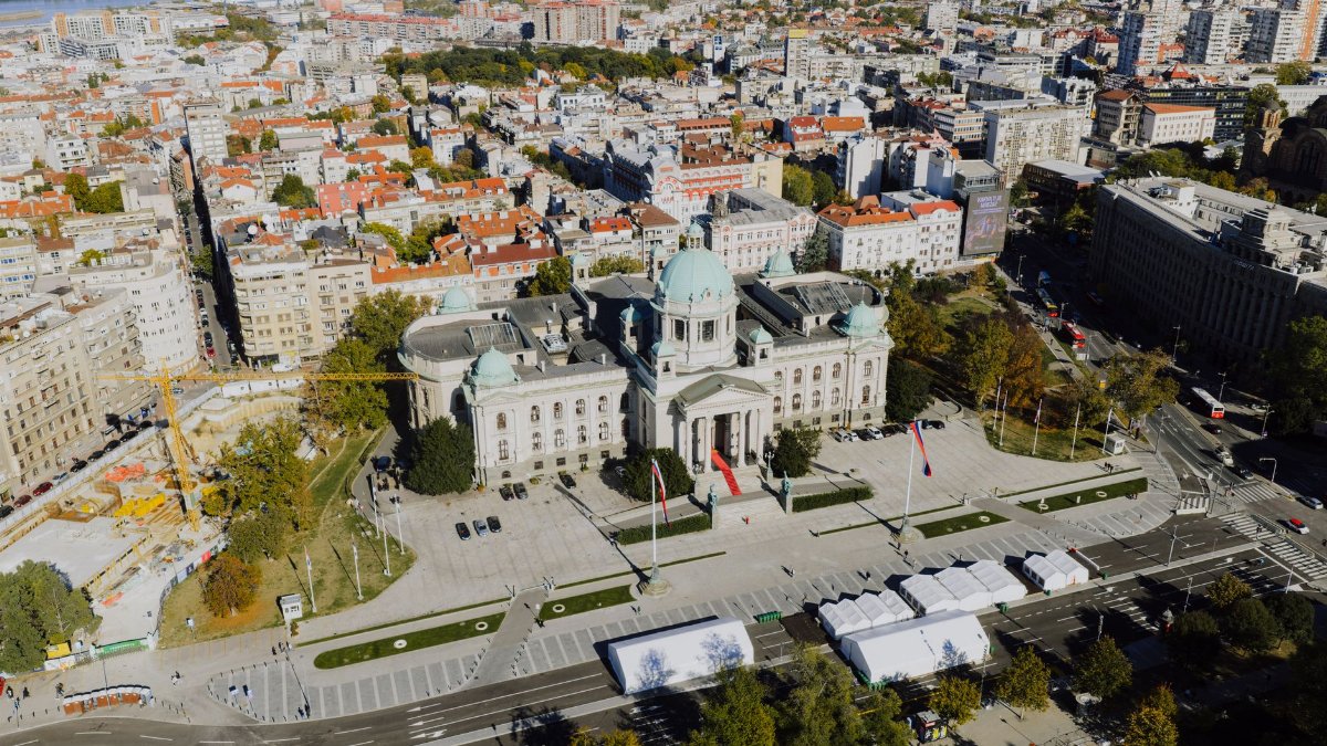 A stunning aerial view of the National Assembly building in Belgrade, Serbia, under clear skies.