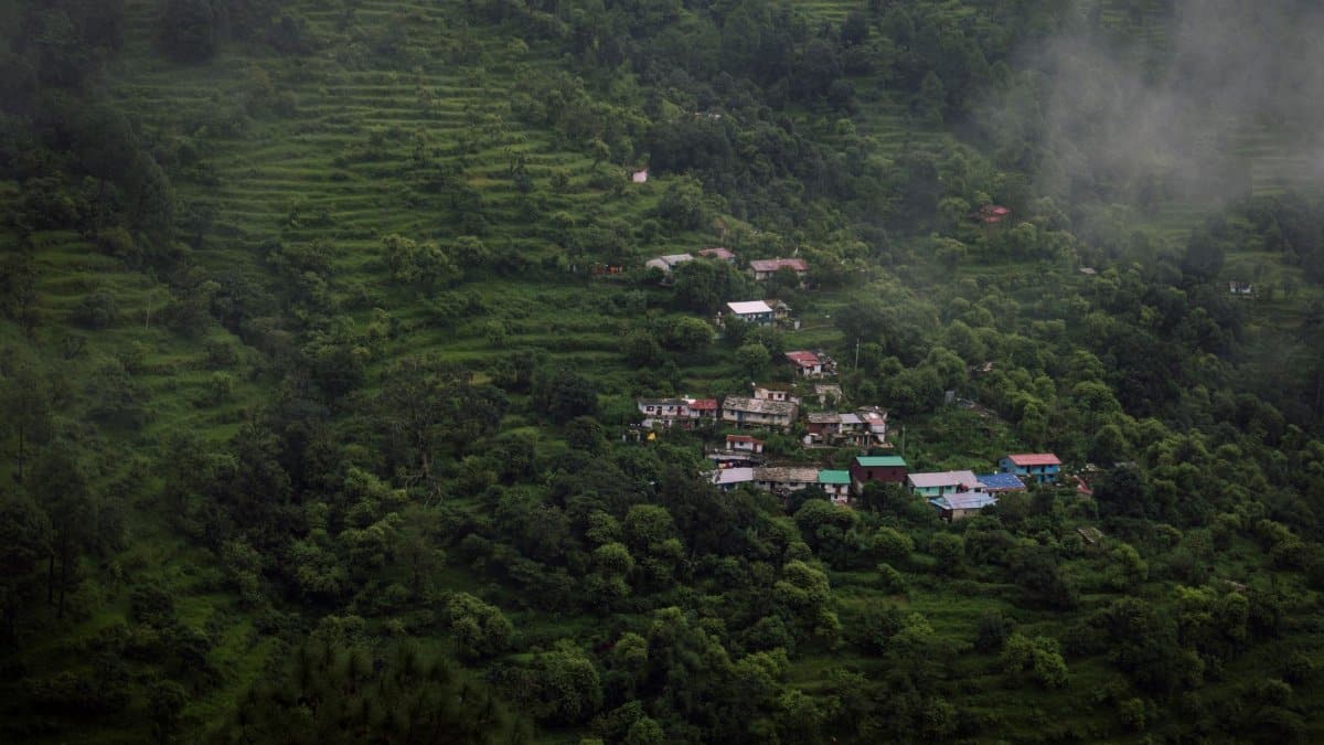 Aerial view of lush green terrain with scattered village houses in Srinagar, India.