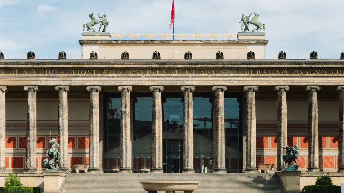 The Altes Museum in Berlin, known for its neoclassical architecture, under a clear sky.