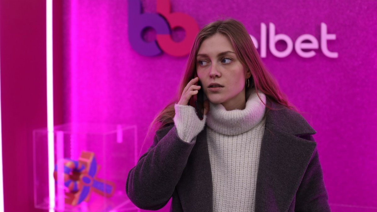 Young woman talks on the phone in a colorful indoor space in Minsk, Belarus.