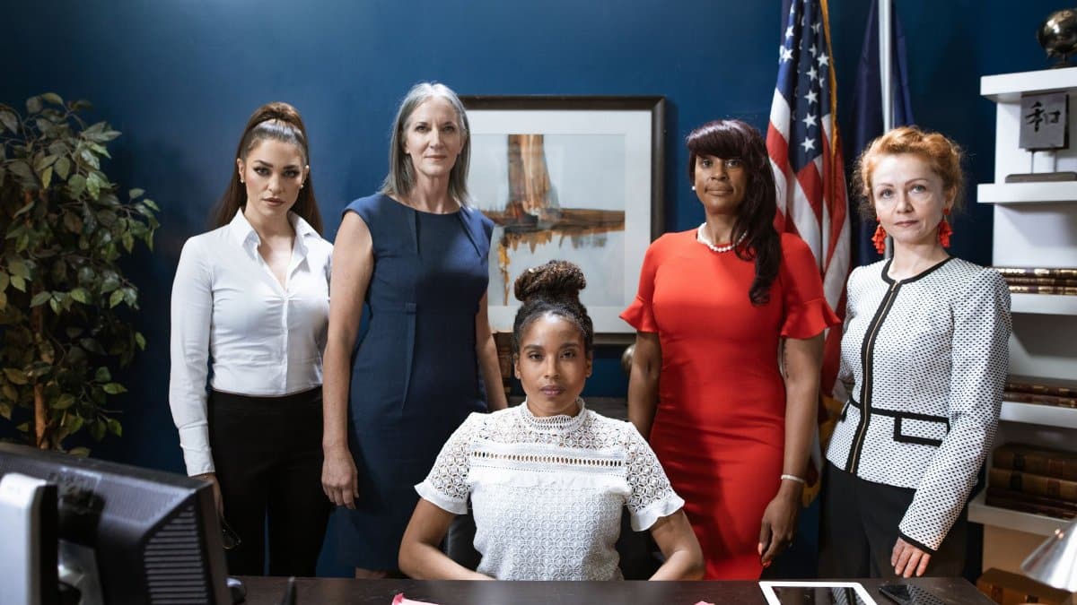 A diverse group of empowered businesswomen posing confidently in a professional office setting.
