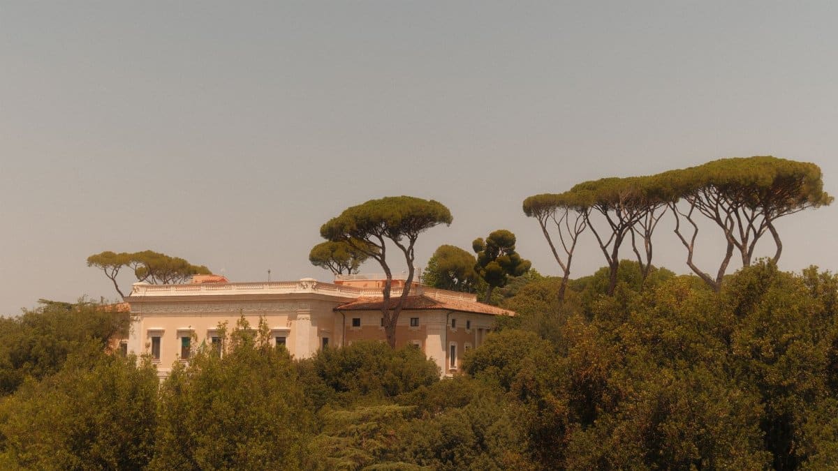 Charming villa surrounded by pine trees in a Mediterranean environment, evoking classic Italian architecture.