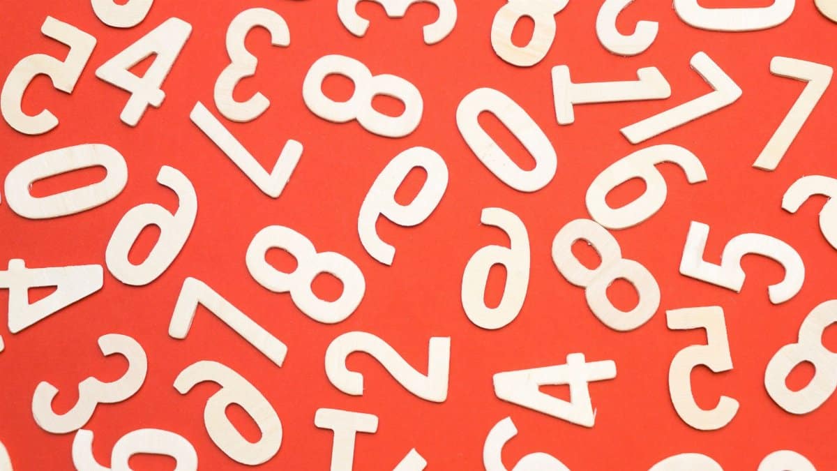 Artistic scattered white numbers on a bright red background, geometric and abstract.