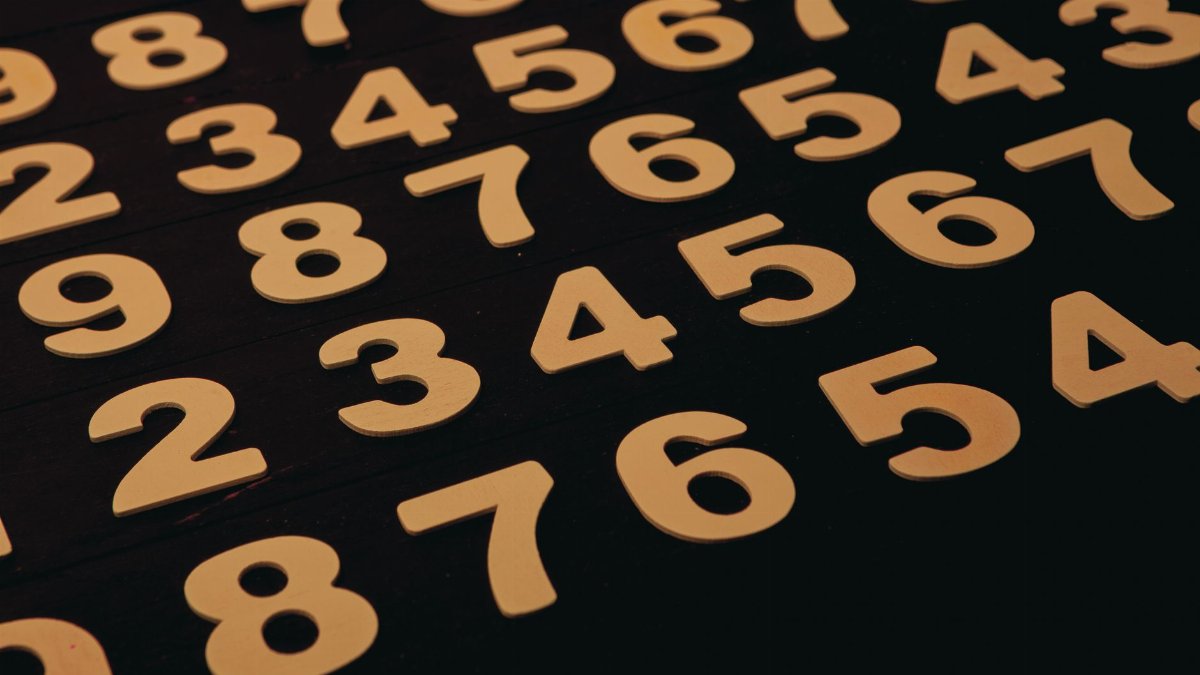 Close-up view of wooden numbers arranged on a black surface, ideal for educational themes.