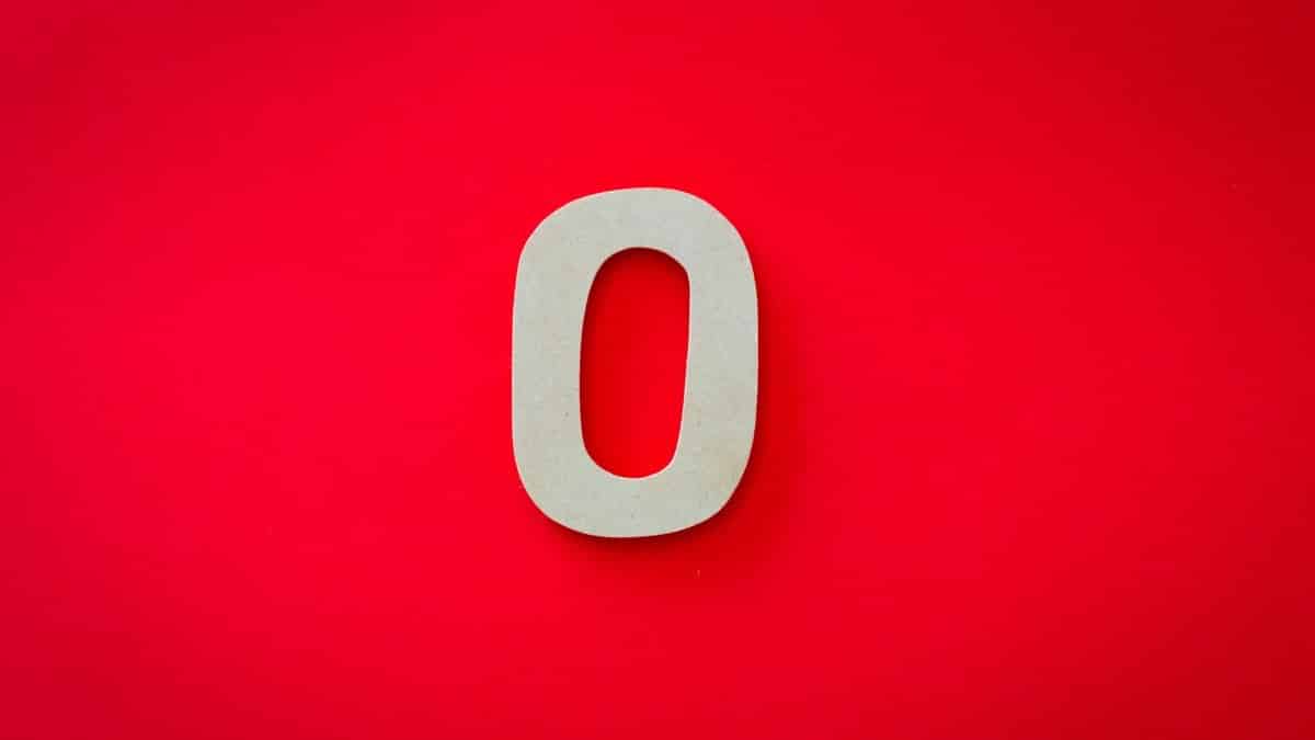 Close-up of a zero cutout on a bright red background with vibrant contrast.