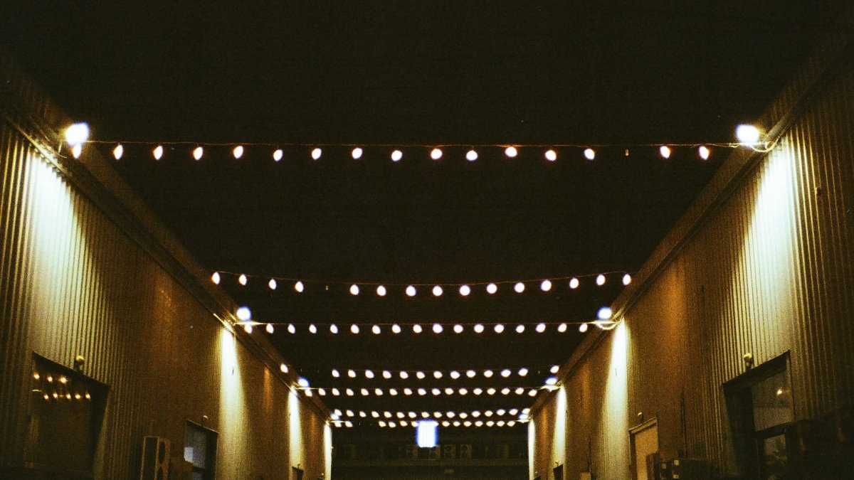 String lights illuminate an industrial walkway at Alserkal Avenue, Dubai, creating a vibrant night scene.