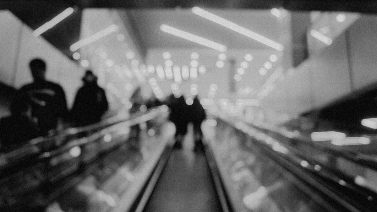 Abstract blurred image of people on an escalator in a subway station.