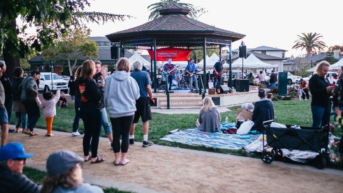 An outdoor concert in a Livermore park with people enjoying music and a vibrant atmosphere.