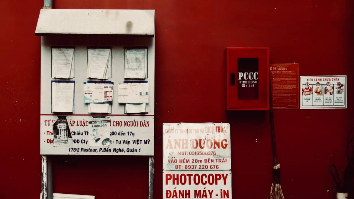 City environment with notices and fire hose on a vibrant red wall.