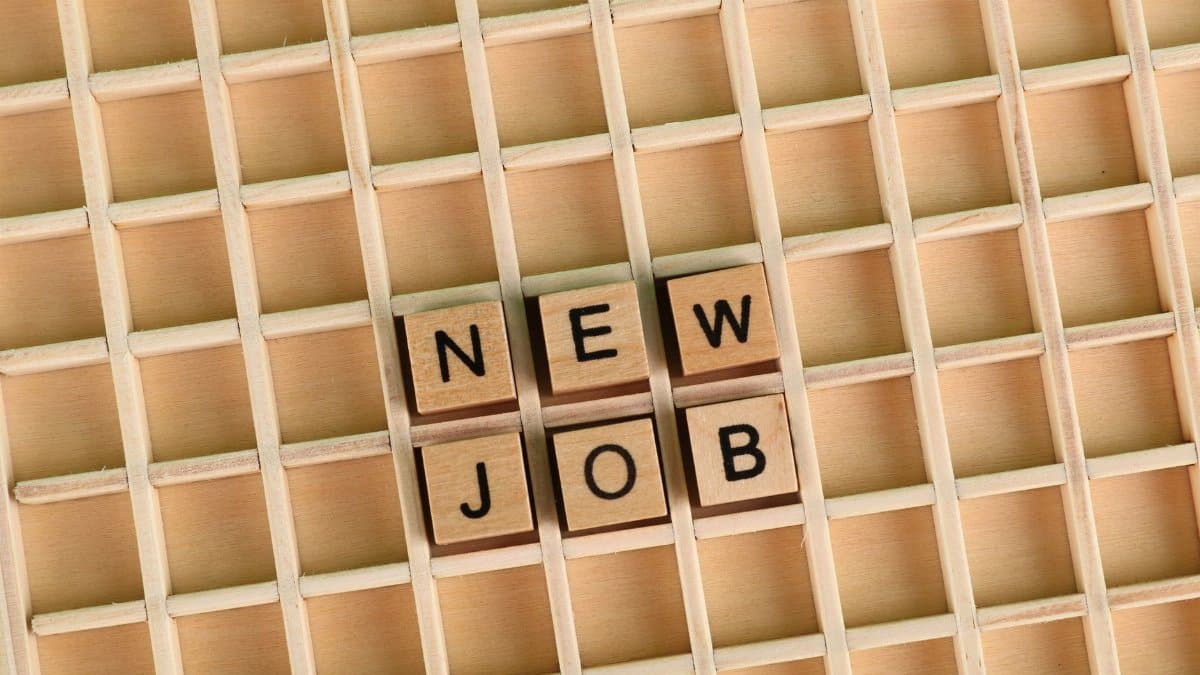 Discover the excitement of a new job with wooden letter tiles spelling 'NEW JOB' on a grid.