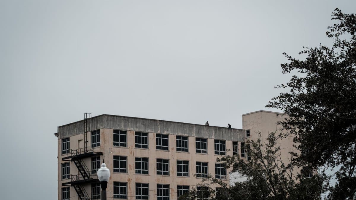 A city building with overcast sky and surrounding trees, showcasing urban architecture.