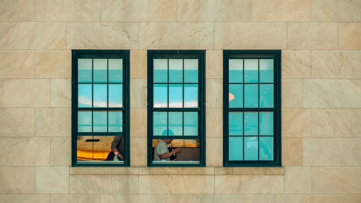Symmetrical window view showing city life inside a New York building facade.