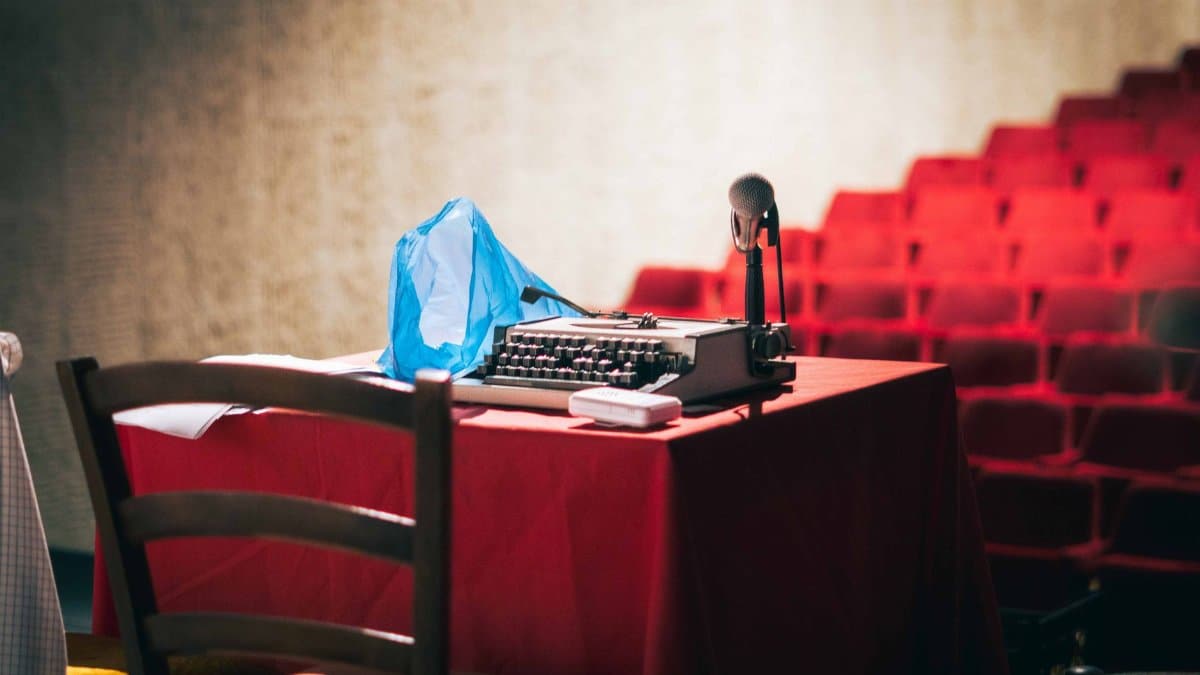 An old-fashioned typewriter with a microphone on a theatre stage sets a retro scene.
