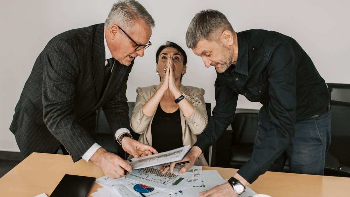 A group of diverse professionals engaged in a focused discussion in a modern office setting.