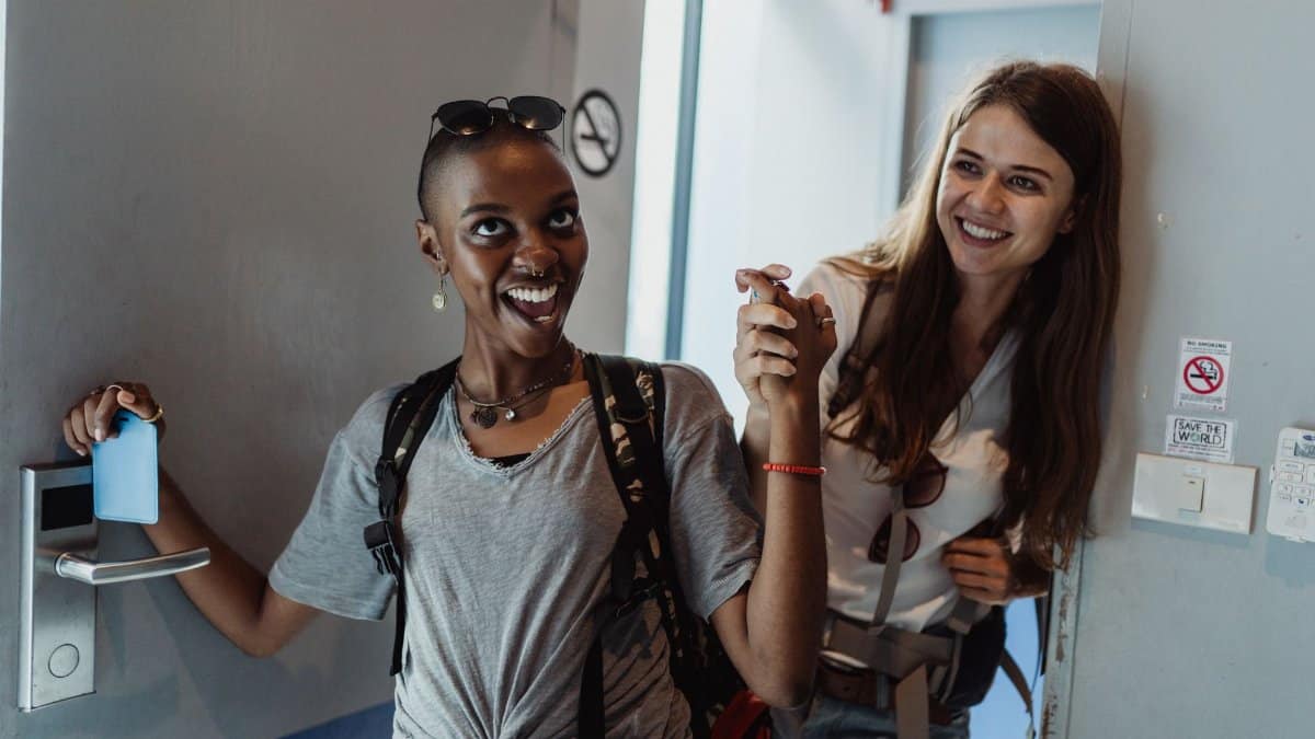 Two cheerful women entering a modern room, capturing moments of fun and friendship.