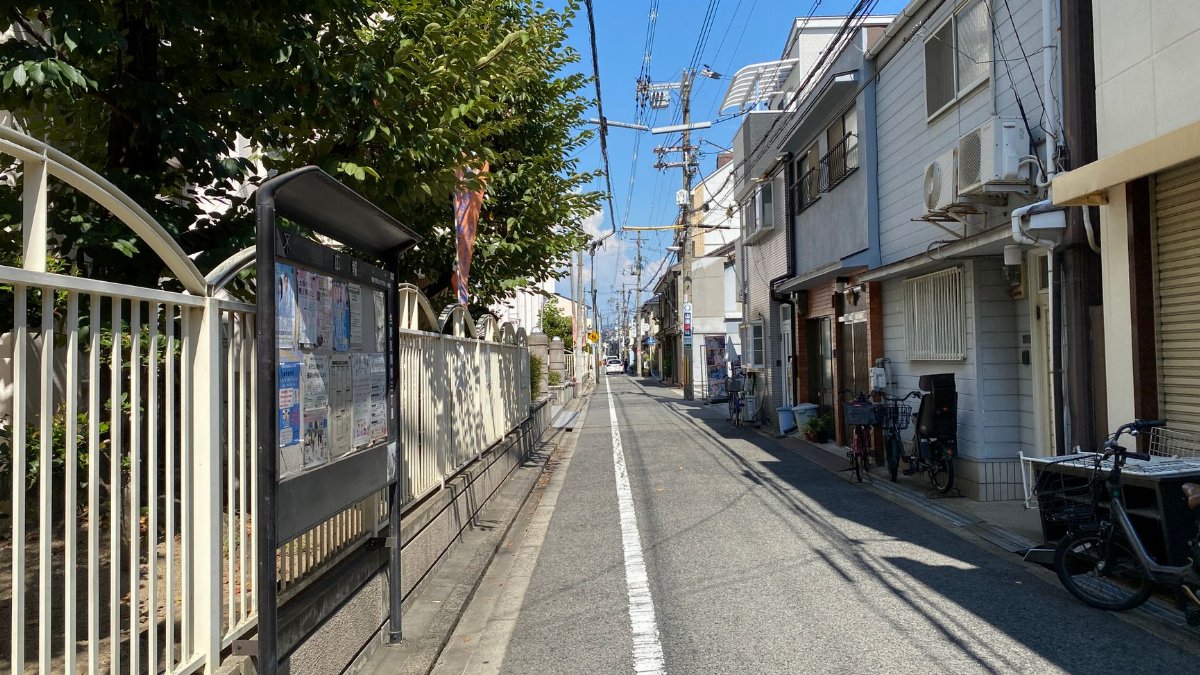 A serene urban street with houses, bicycles, and clear blue sky, showcasing daily life.