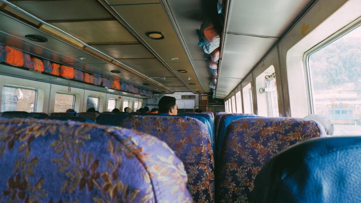 View from inside a public bus with patterned seats, capturing the atmosphere of commute.