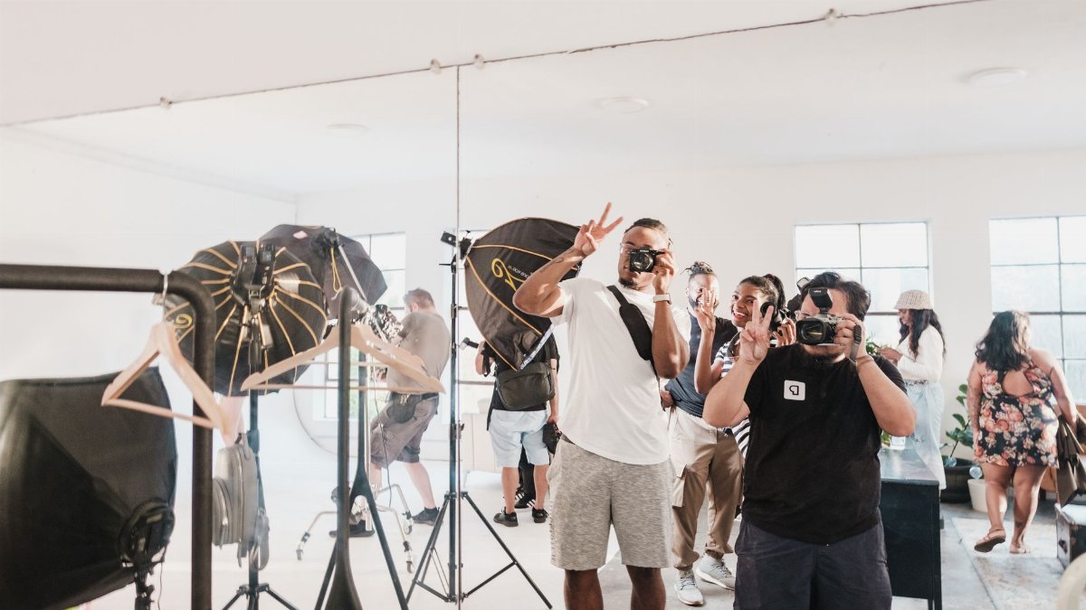 Lively photo session in a bright studio setting, capturing photographers and models in action.