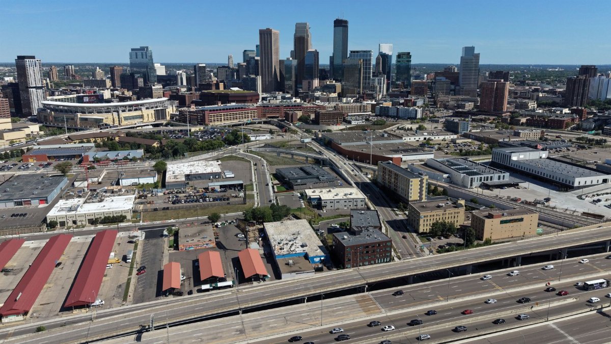 Aerial view of the Minneapolis skyline showcasing downtown and major highways on a clear summer day.