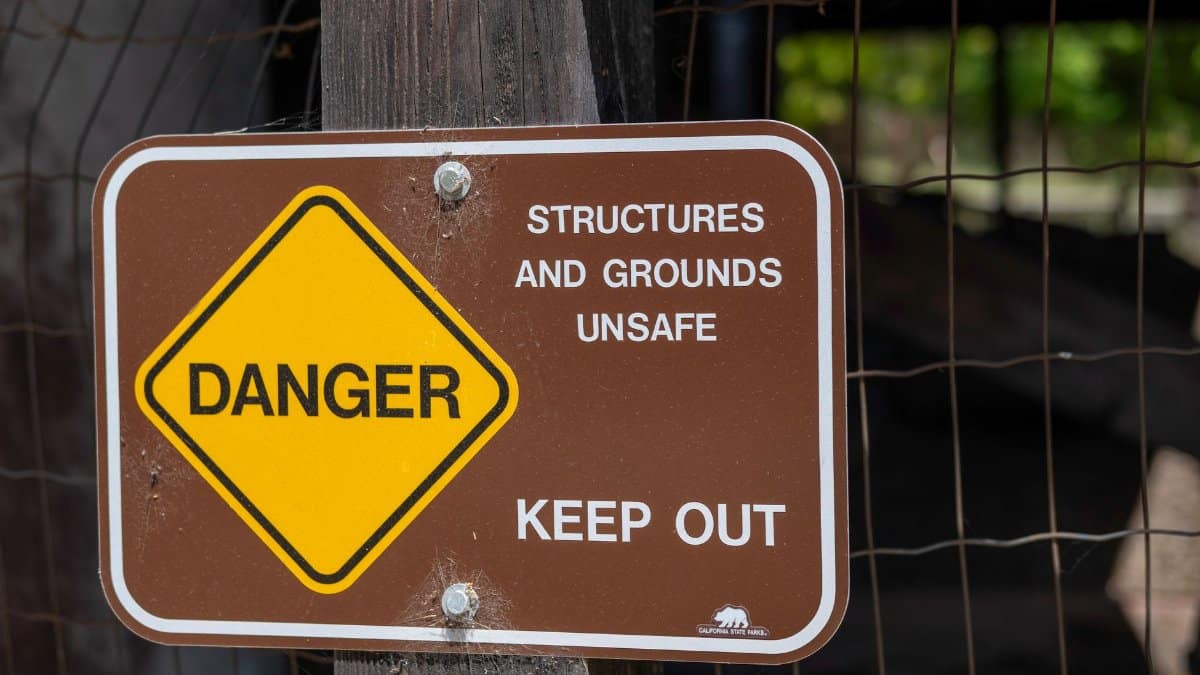 Danger sign warning about unsafe structures and grounds with keep out notice.