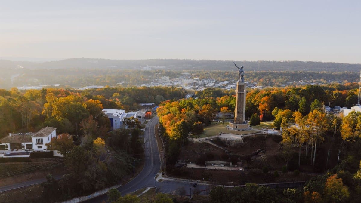 Drone view of Vulcan Park and fall foliage in Birmingham, Alabama at sunset.