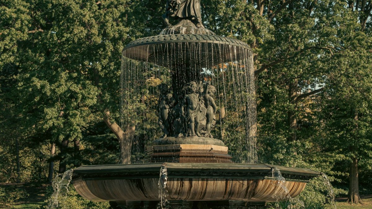 Elegant view of the Bethesda Fountain in Central Park, New York City, surrounded by lush greenery.