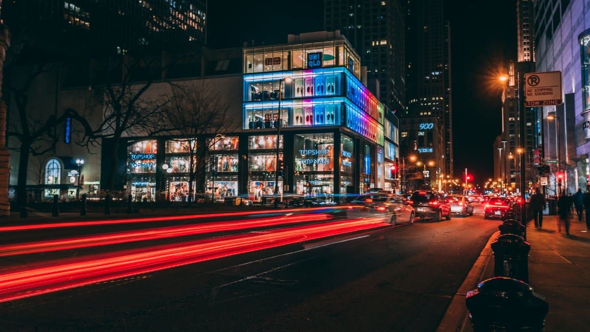 Dynamic Chicago city street at night with light trails and illuminated buildings.