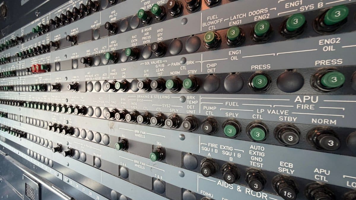 Detailed view of an airplane avionics control panel featuring numerous switches and indicators.