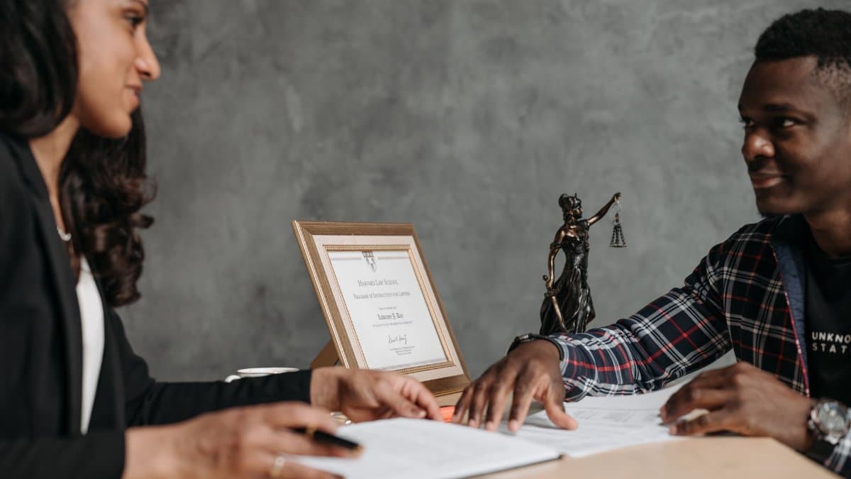 Two professionals engaged in a discussion over legal documents in an office setting.