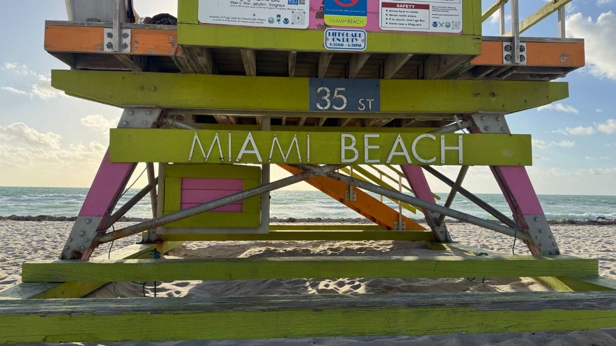 Vibrant lifeguard stand on Miami Beach with ocean view and clear sky.