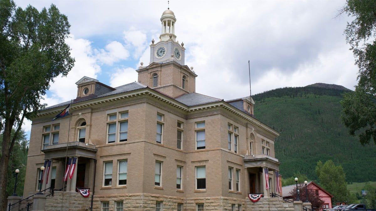 The classic architecture of San Juan County Courthouse in Silverton, Colorado, nestled in a mountain town setting.