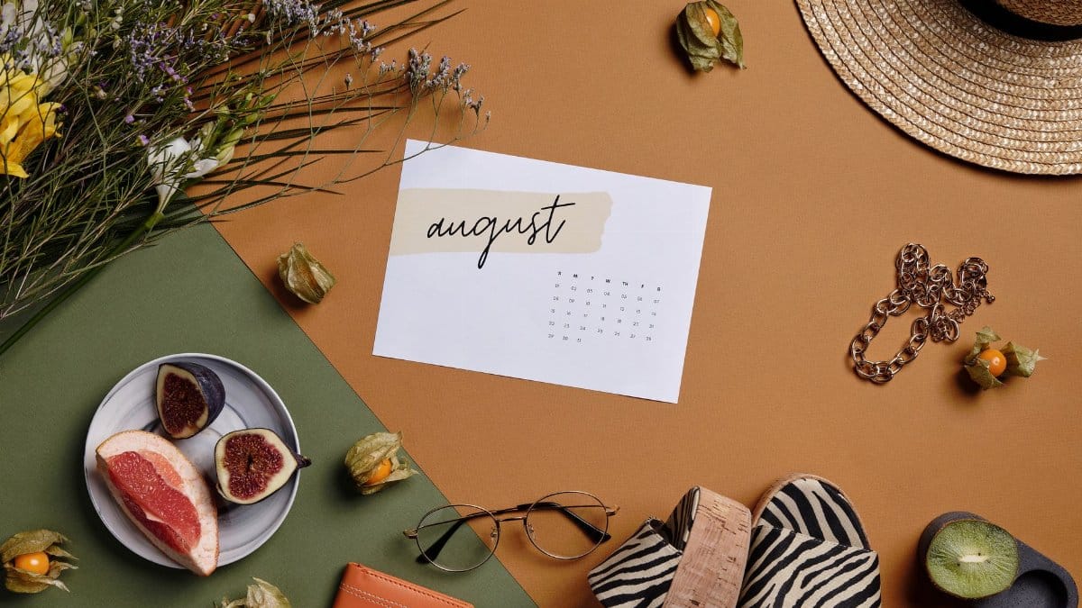 Aesthetic summer arrangement with fruits, flowers, and August calendar.