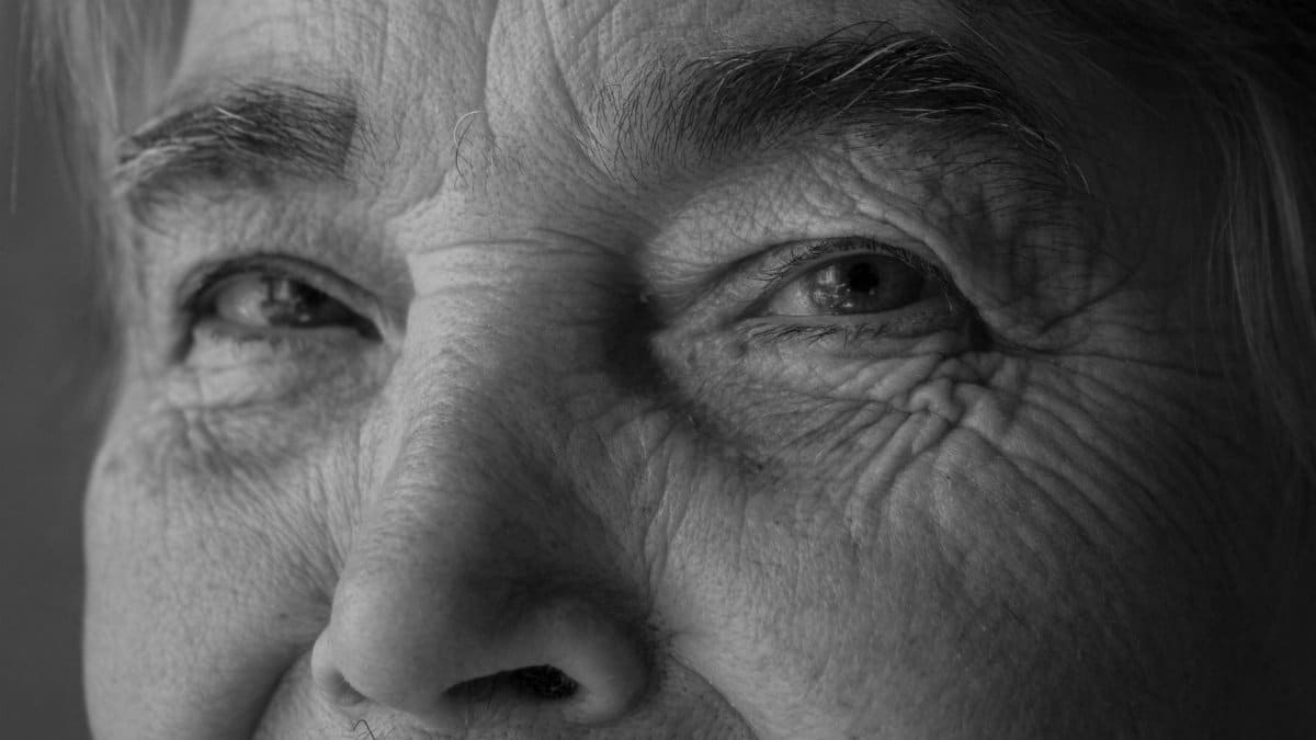Intimate black and white portrait showing the details of an elderly person's face.