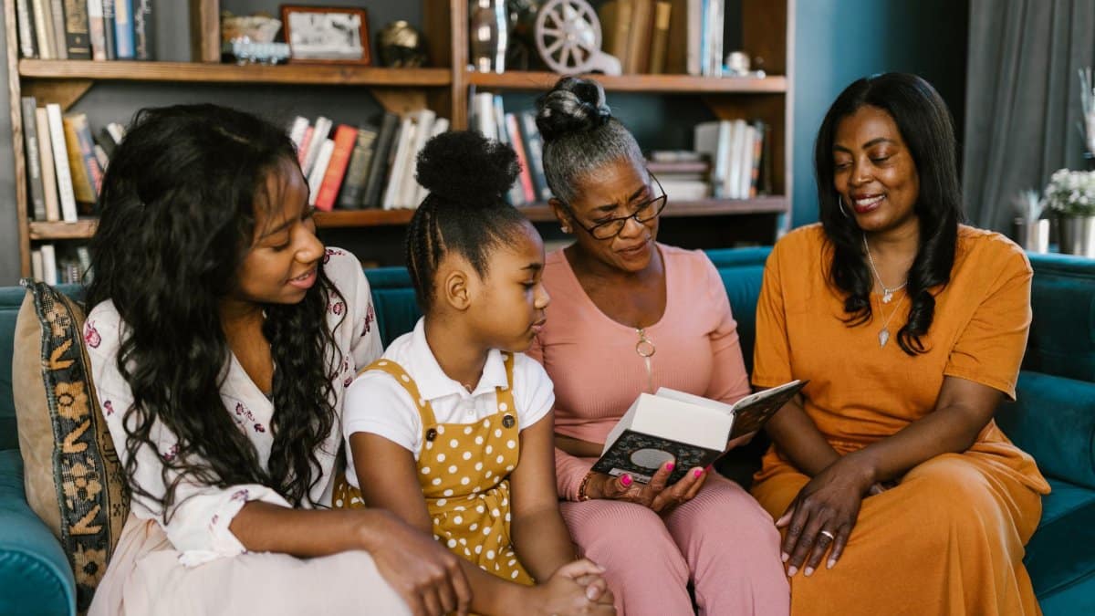 A multigenerational family enjoys reading at home, sharing smiles and togetherness.