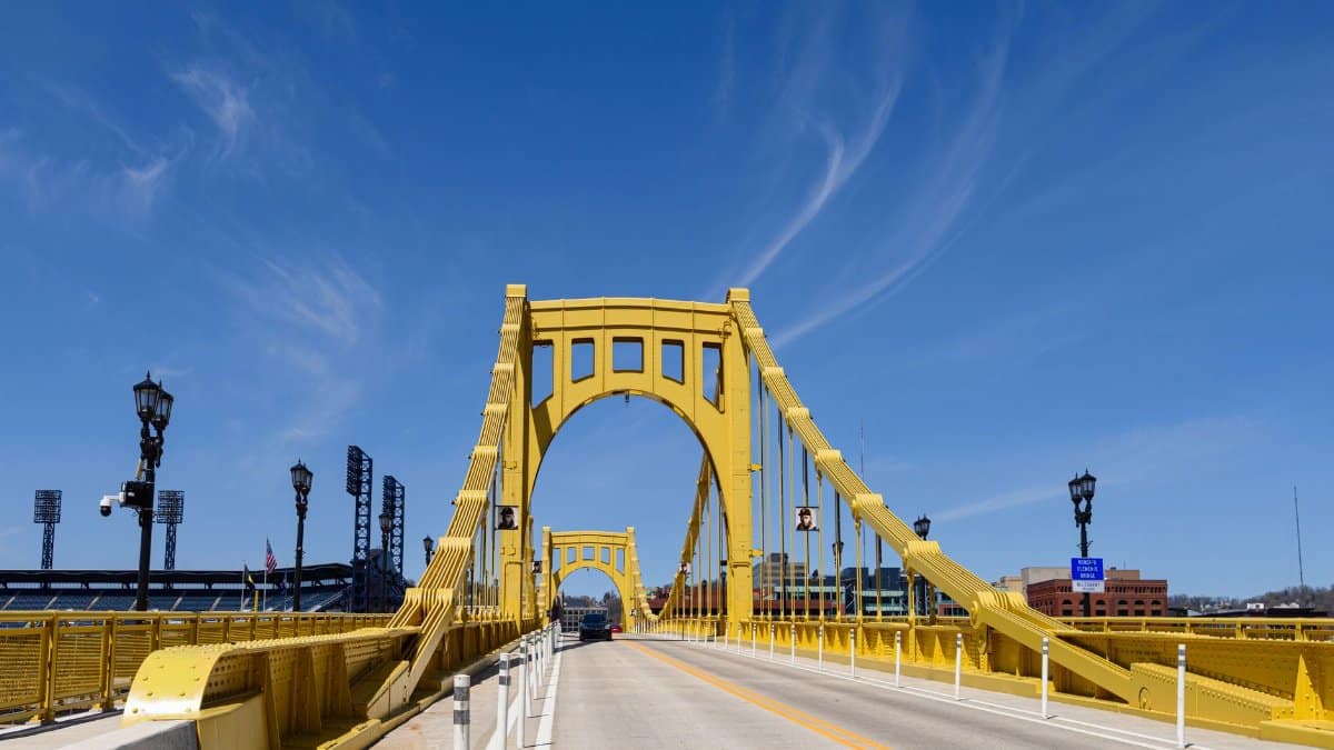 The Roberto Clemente Bridge stretches under a vibrant blue sky in Pittsburgh, PA.