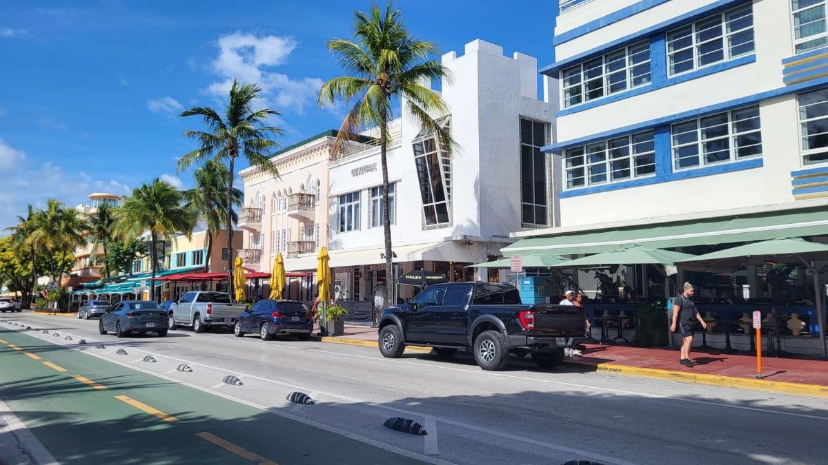 Vibrant street scene in Miami's South Beach showcasing iconic Art Deco buildings and palm trees.