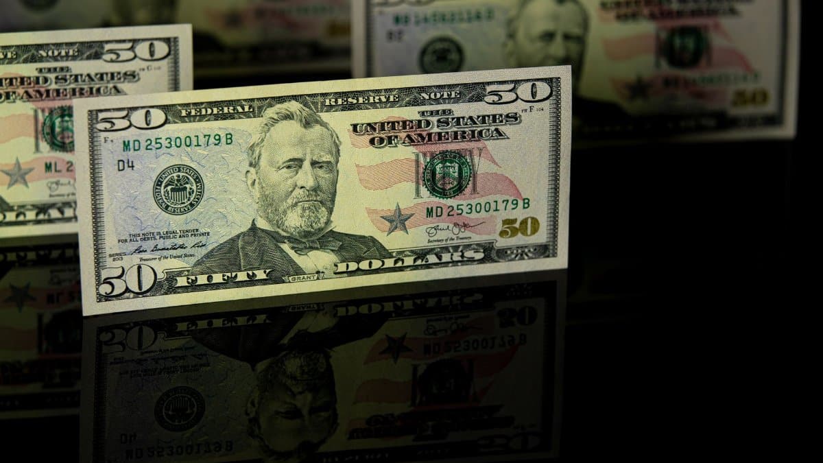 Crisp 50 dollar bill with reflection, offering a detailed view perfect for financial themes.