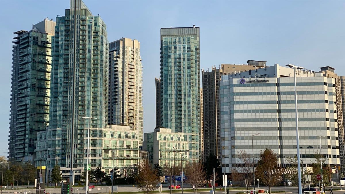 Photo of a city skyline featuring modern high-rise buildings with a clear blue sky.