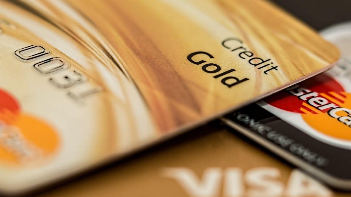 Stack of various branded credit cards focusing on gold card showing finance and cashless concept.