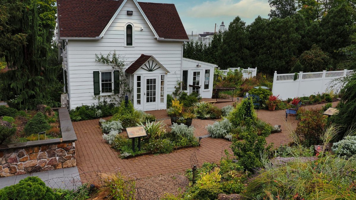 A picturesque white house surrounded by a vibrant garden in Morristown, New Jersey, USA.