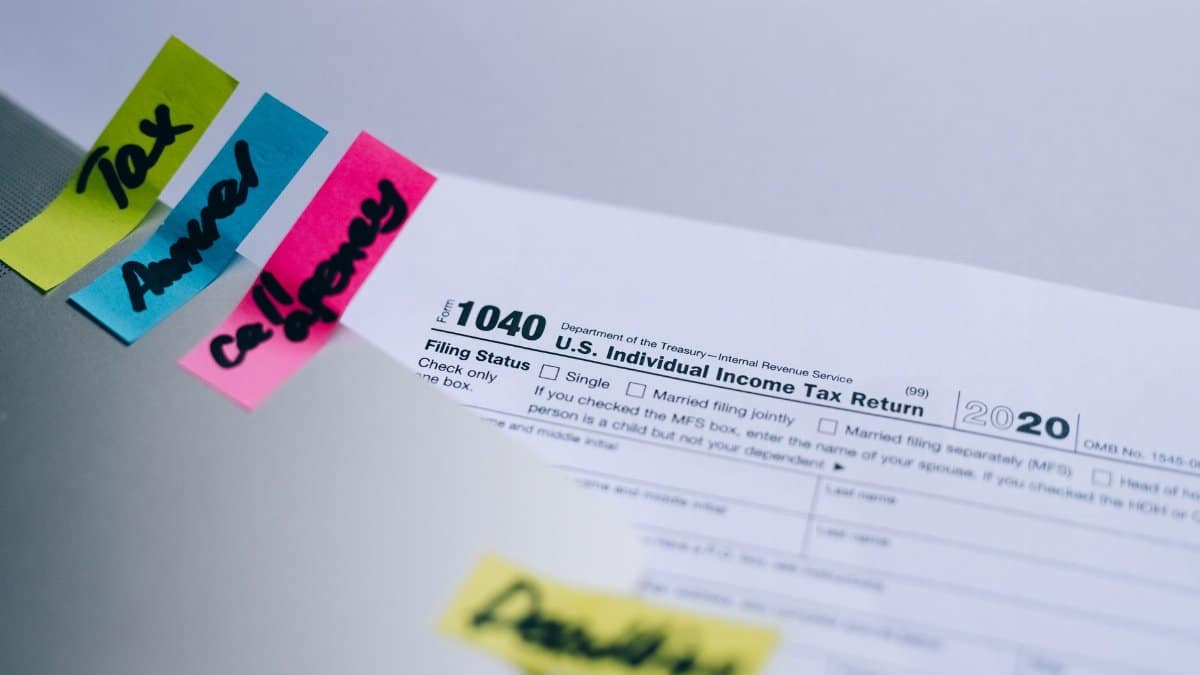 Close-up of 1040 U.S. tax form with colorful sticky notes for organization.