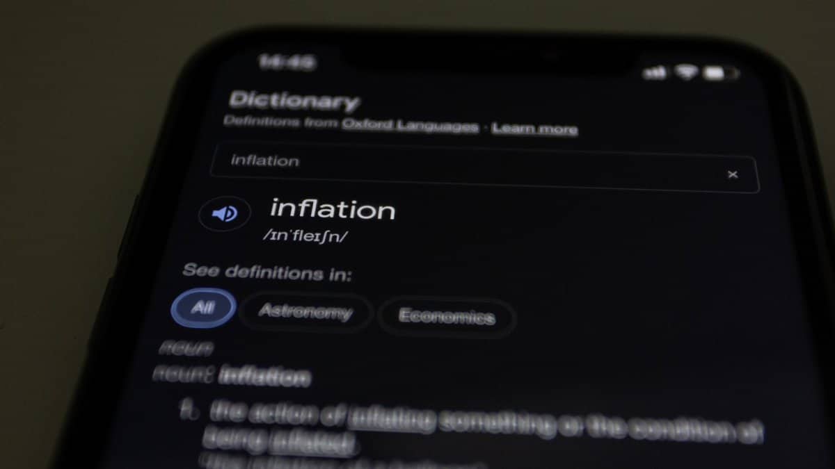 Close-up of a smartphone screen showing the word inflation defined in a dictionary app.