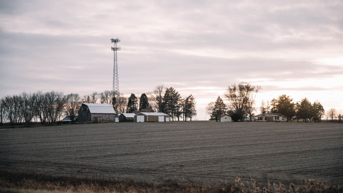 A serene rural farm landscape at sunrise featuring fields and a distant cabin in Dixon, Illinois.