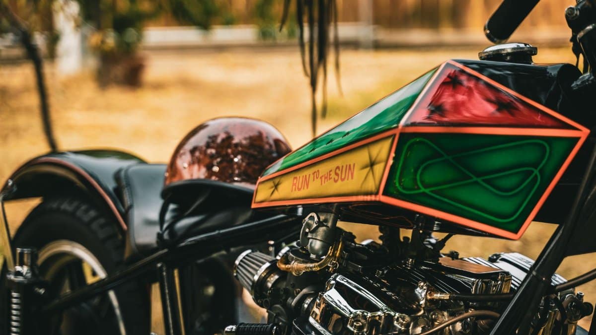 Artistic close-up of a custom chopper motorcycle with intricate designs outdoors.