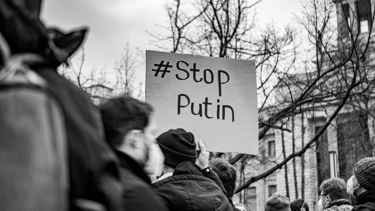 Black and white photo of a Berlin protest with a Stop Putin sign.